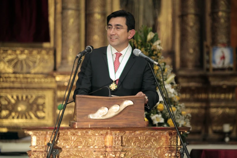 a man at a podium wearing white shoes