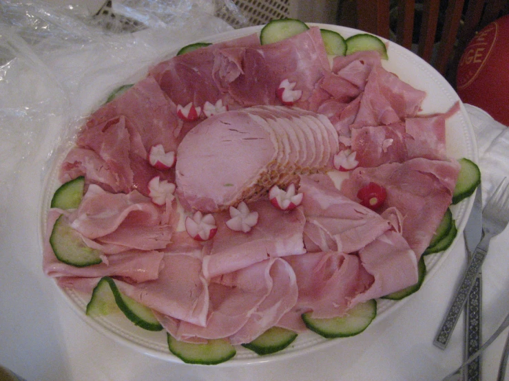 a white plate filled with cucumber and ham