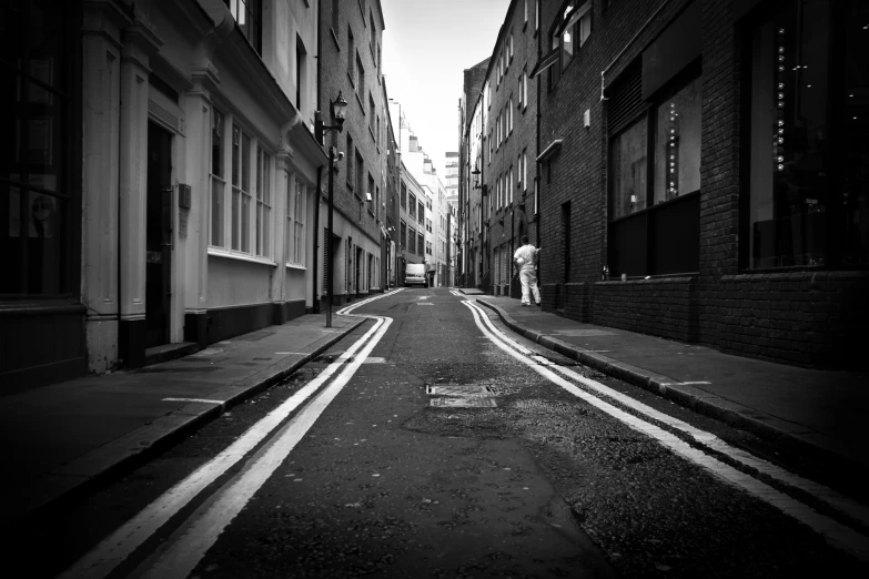 the man walks alone down the narrow street in the city