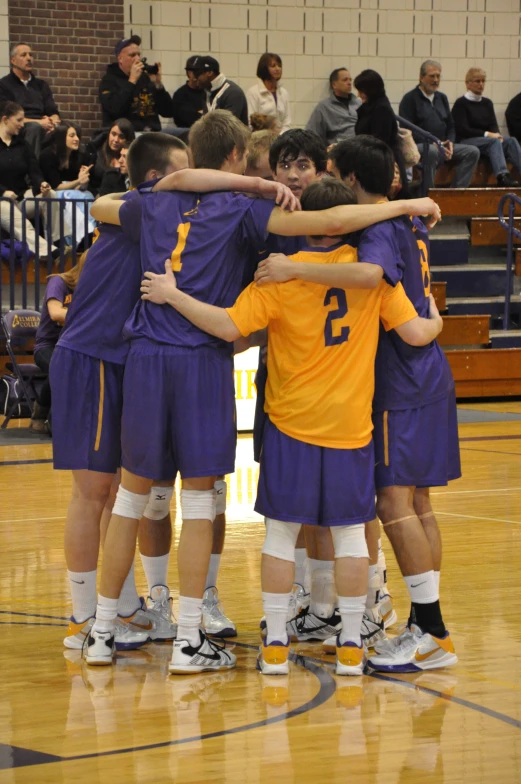 a group of young men huddled in a huddle at a basketball game