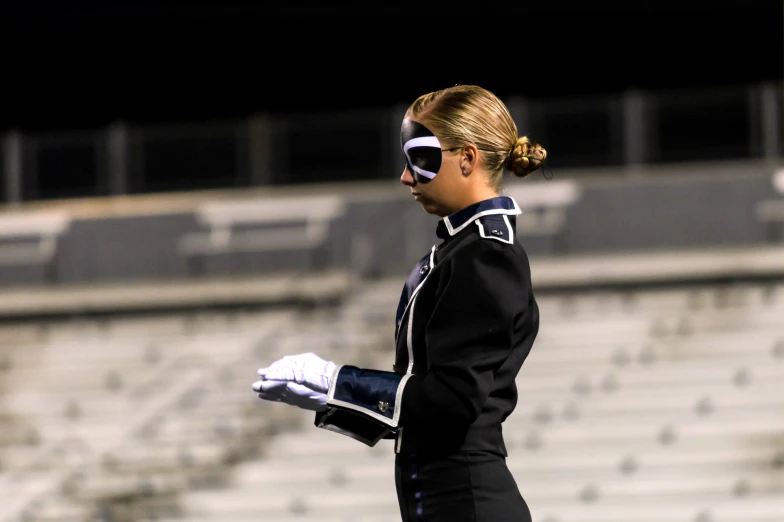 a woman in cheer gear with white gloves walking on a field