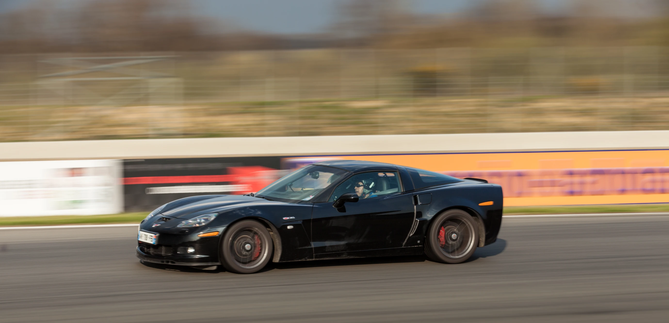 a black sports car speeding around a track