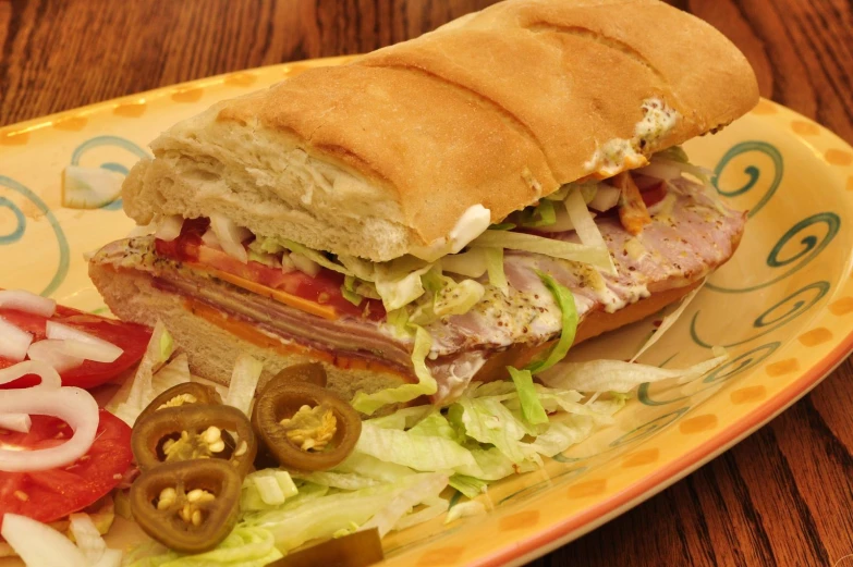 this delicious sandwich contains meat, tomatoes, onions and lettuce