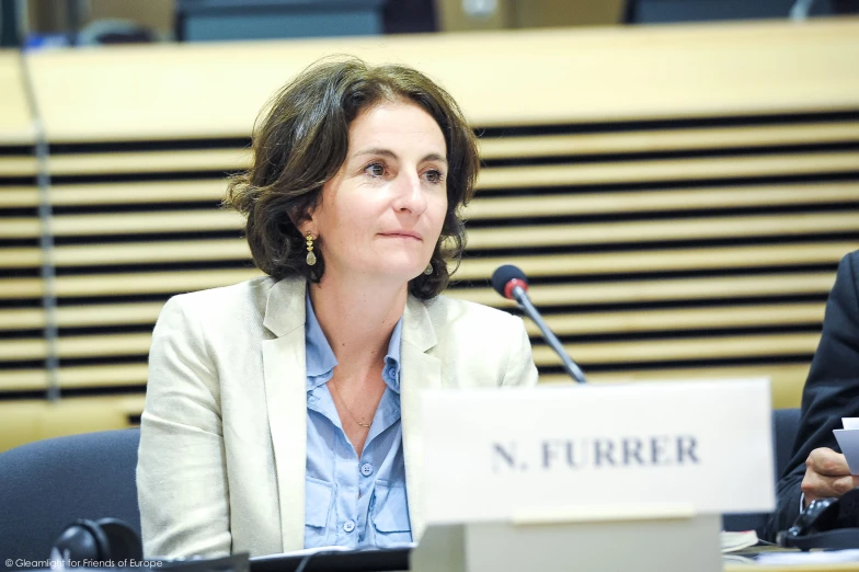 a woman is sitting in front of a microphone