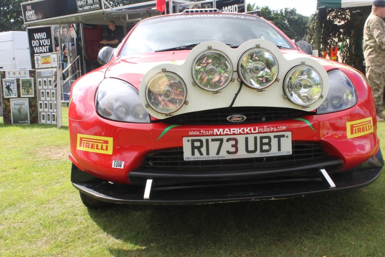 the front end of a red car with its hood folded over it