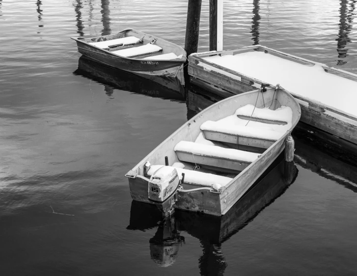 two small boats are sitting in a calm water