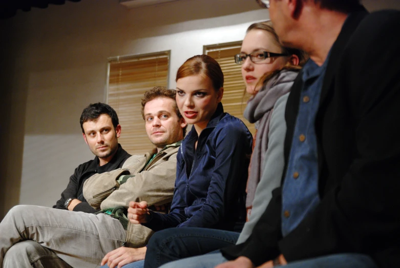 five people are sitting side by side in a group