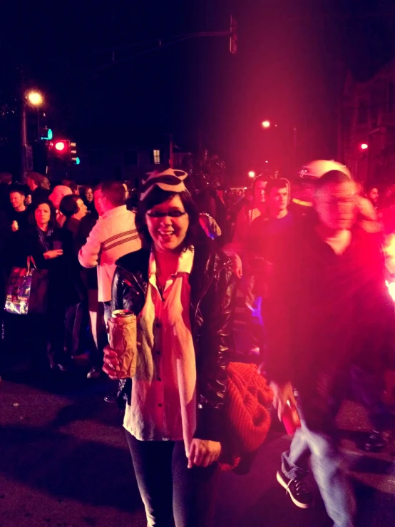 a woman smiles while standing among a group of people