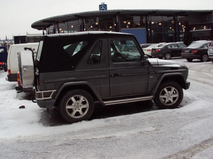 an suv with the door open parked on a snowy parking lot