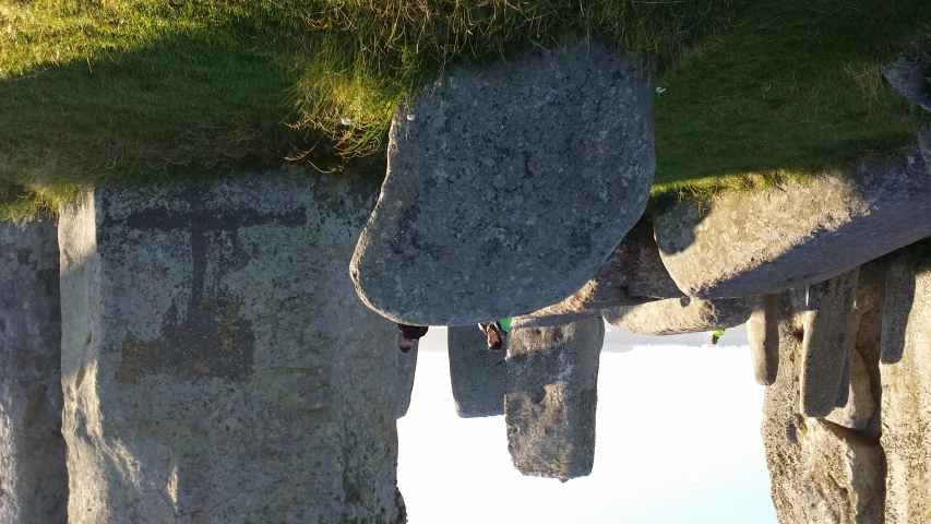 a group of people are standing around large stones