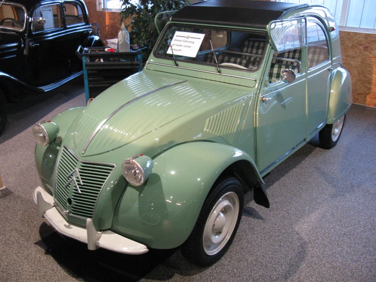 this is an old green car on display
