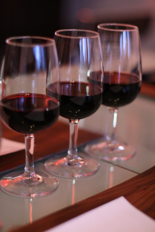 four glasses of wine sit next to each other on a table