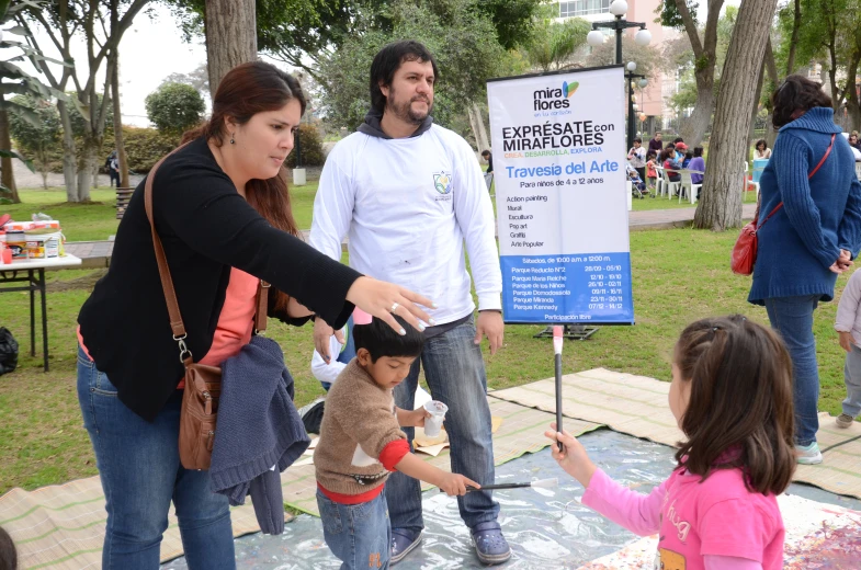 a person handing soing to a child at a park