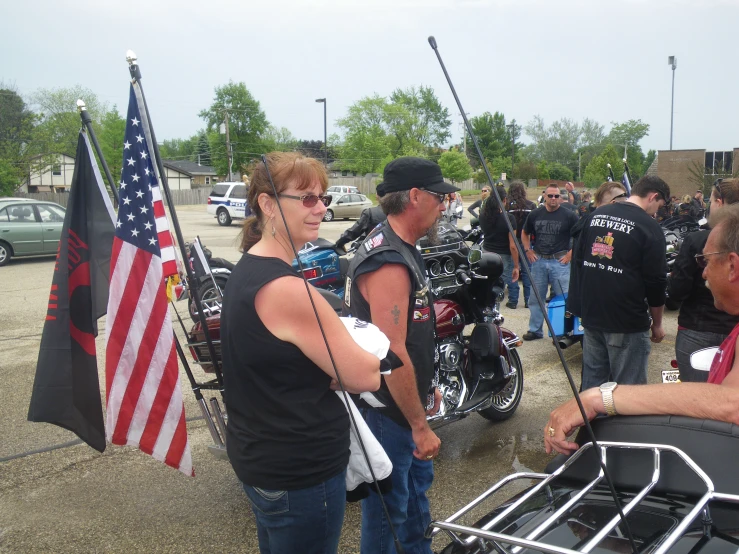 the bikers are standing by their motorcycles