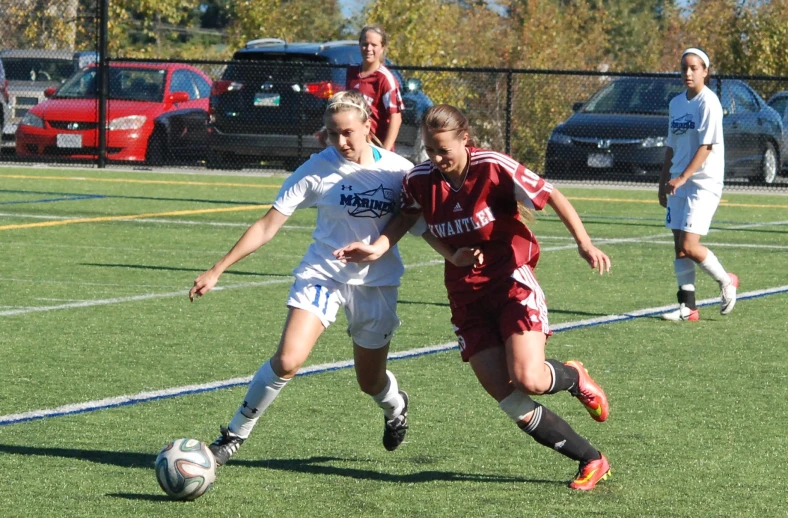 the two young ladies are playing soccer together