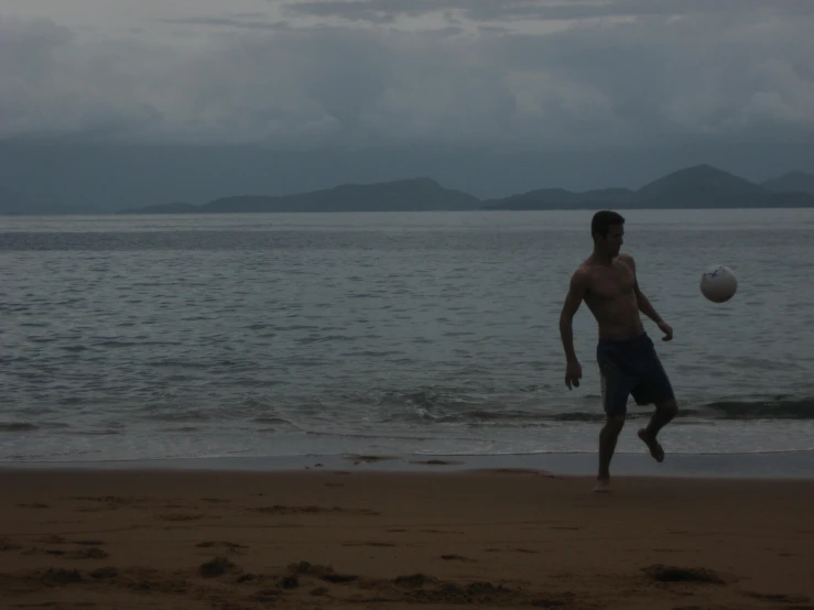 the man is playing frisbee on the beach