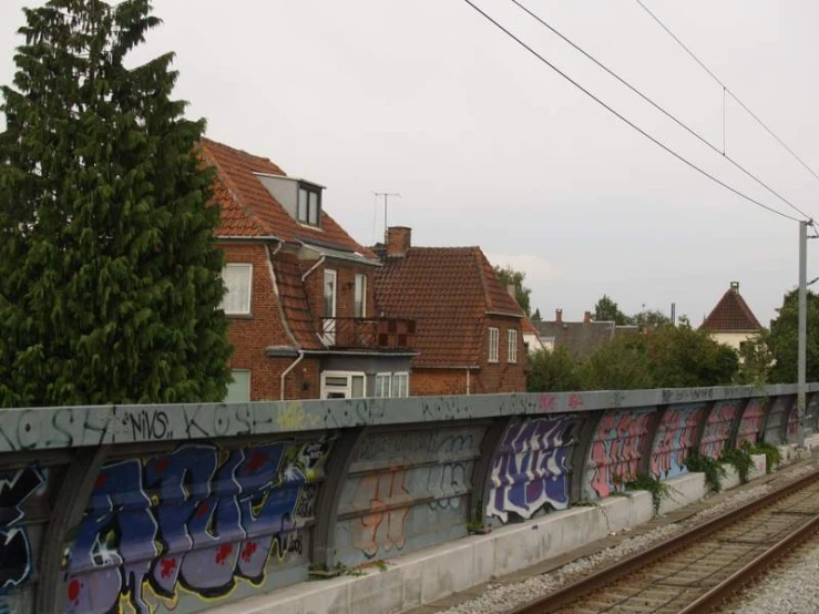 graffiti on the side of a rail near railroad tracks