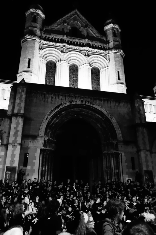 a large crowd of people standing in front of a tall building