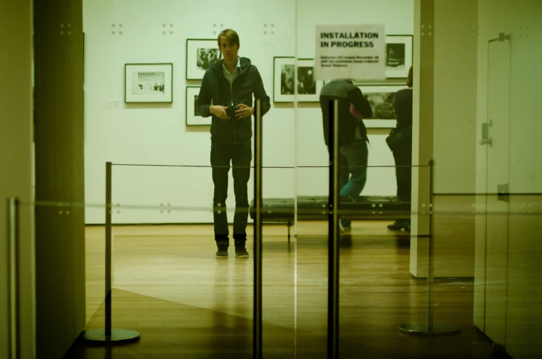 two men walking in a room next to a railing