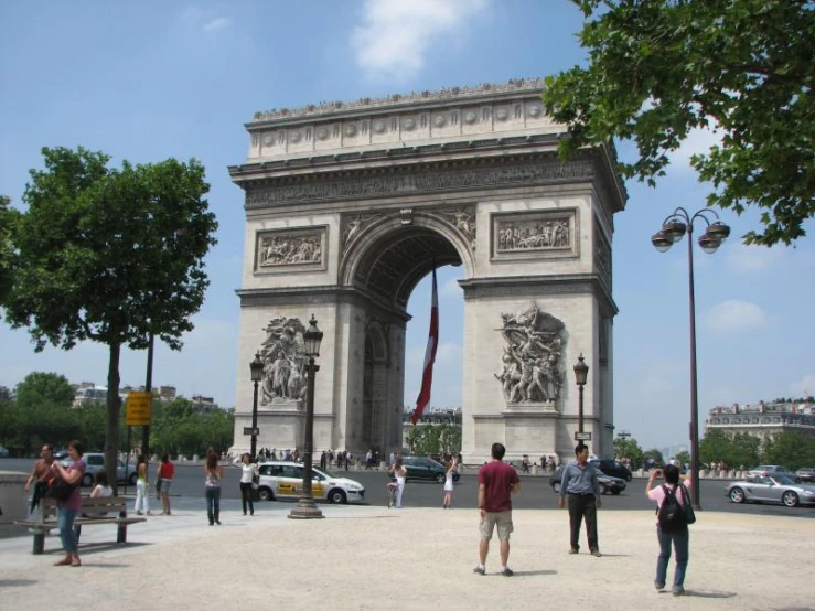 people are walking around in front of the arch of triumph