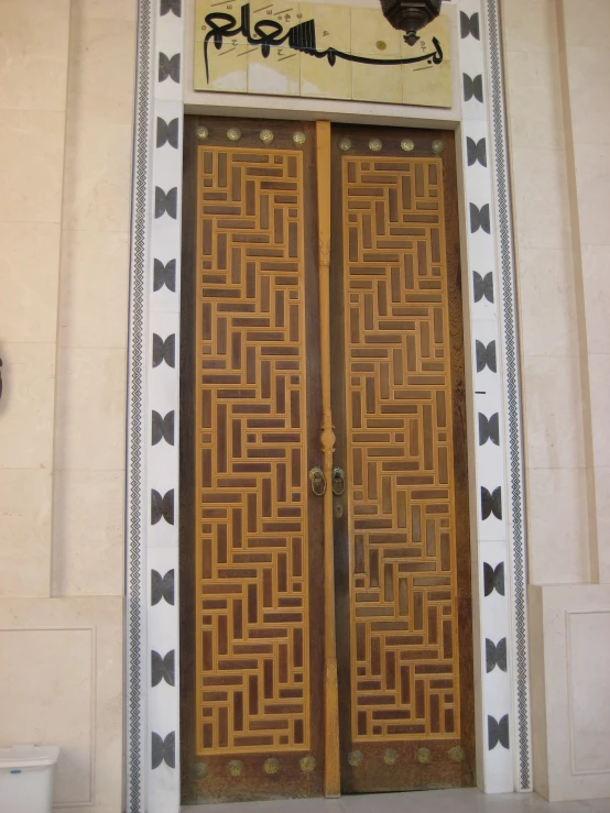 two very elaborately decorated wooden doors with a clock on the wall behind them