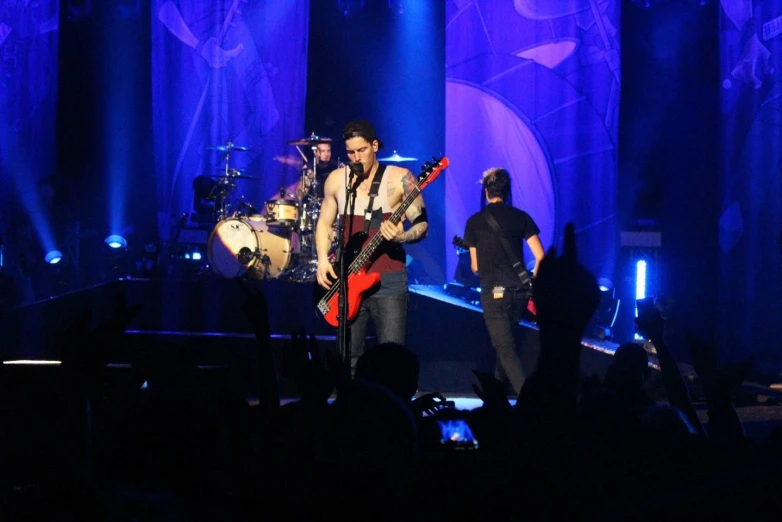 two people singing on stage and one playing an electric guitar