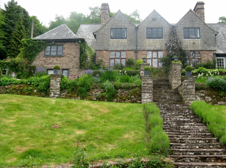 a stone house that is sitting next to some grass