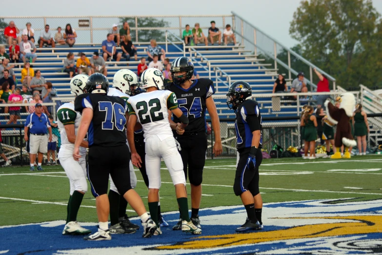 several boys playing a game of football against a crowd