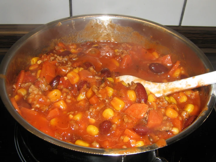 stew with tomatoes and corn is shown in a pan