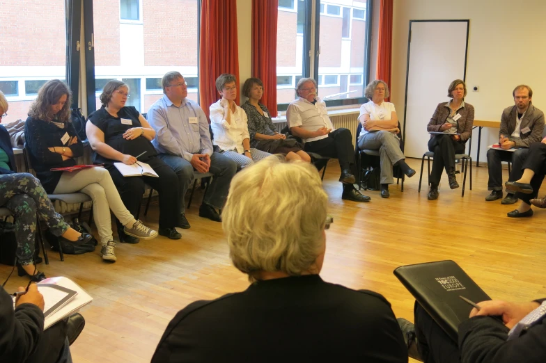 a group of people sitting in a room with books