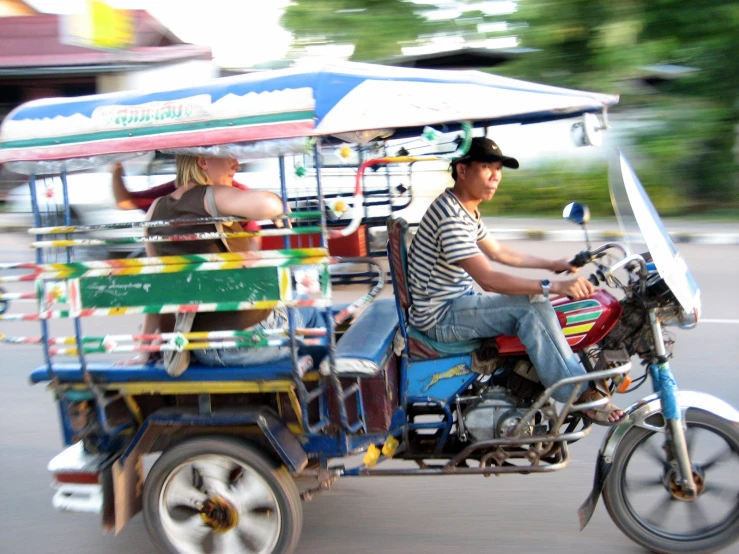 a man and woman are riding on a small motorcycle