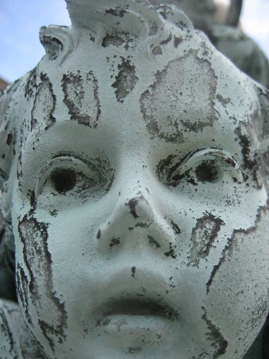 an image of a statue of a child that has mud all over its face