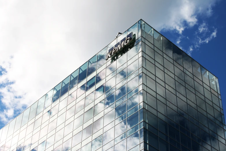 a large modern glass and steel building with cloudy sky above