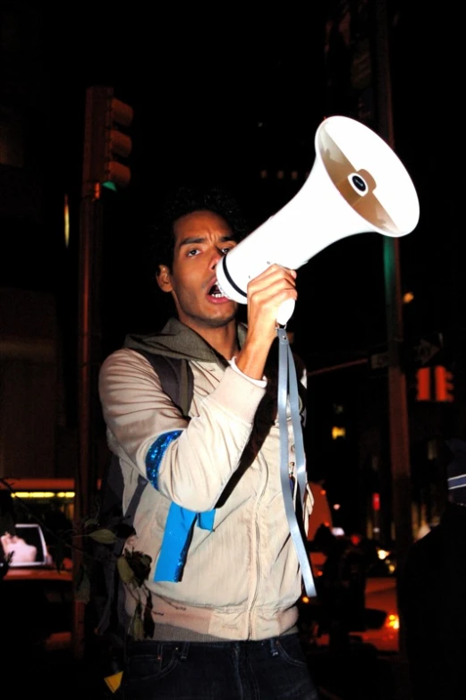 a man holding up a white and brown megaphone