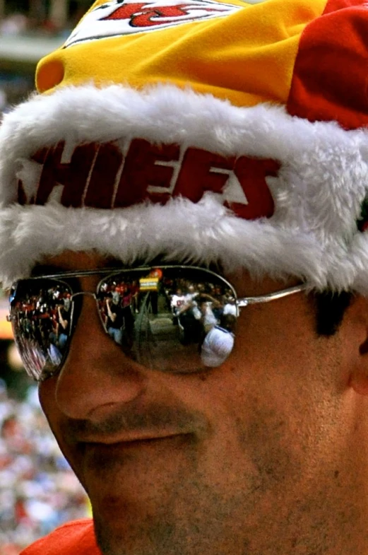 a man wearing sunglasses and a red and yellow hat