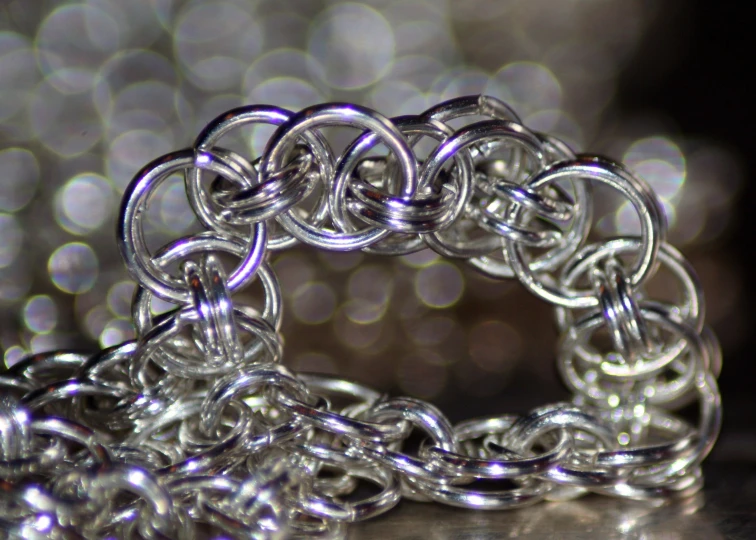 an intricate silver ring sitting on top of a table