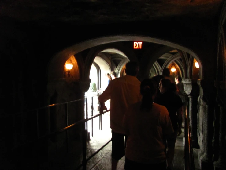 people are walking around an entrance in a cave