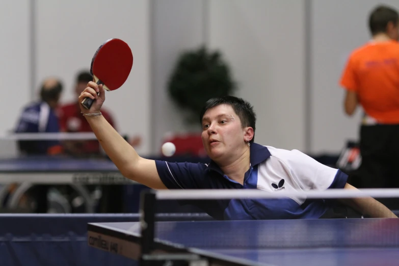 a man with a ping pong paddle is playing table tennis