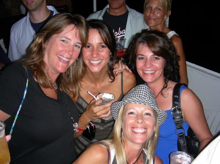 five women drinking beers in front of many others