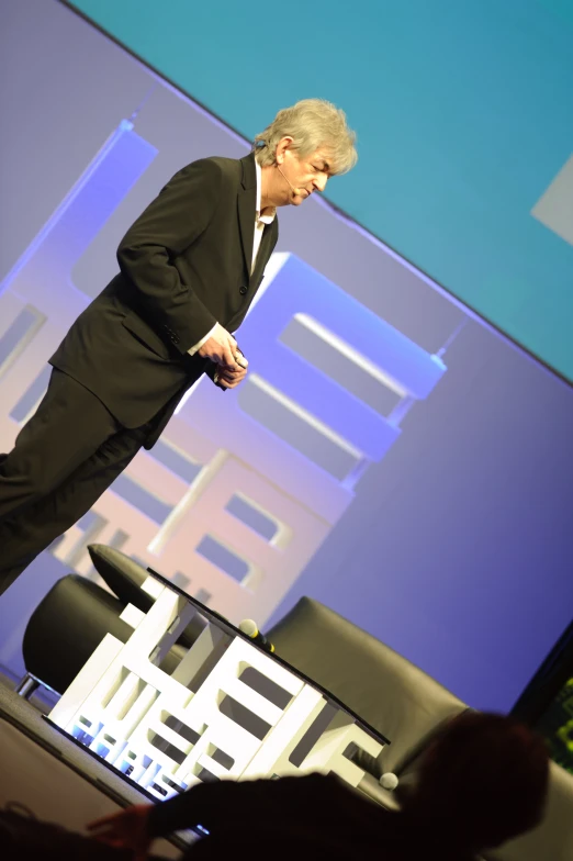 a man standing on stage at a presentation