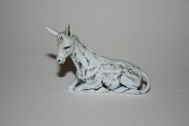 a miniature horse toy figurine is shown on a white surface