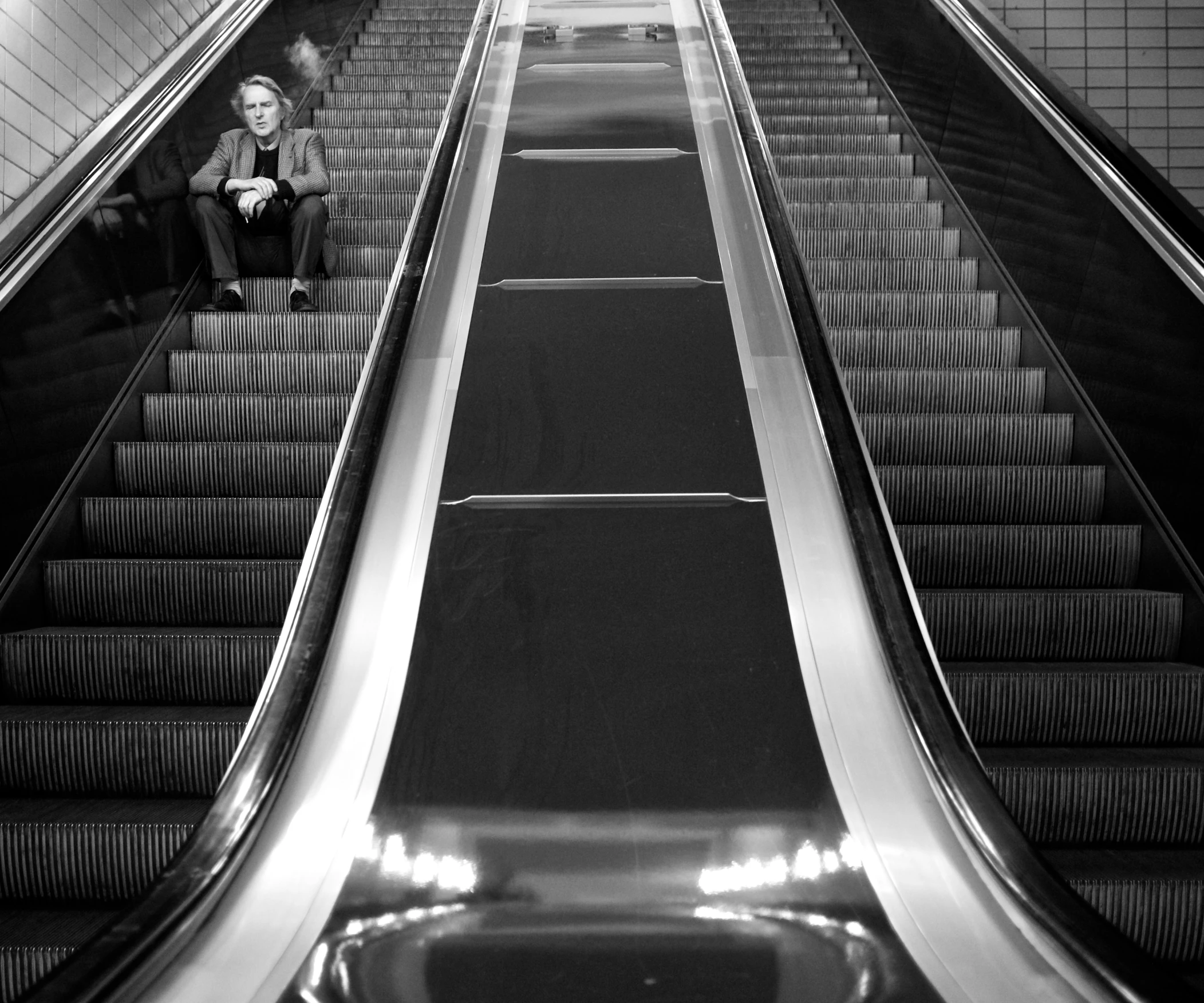 an escalator in a subway building with a man on the top