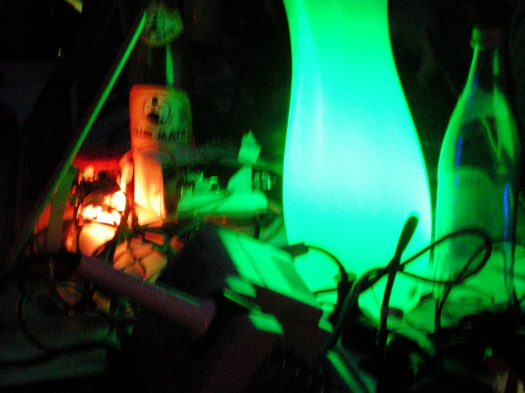 two bottles of wine illuminated at night with bright green lights