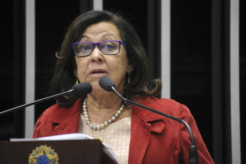 the woman is standing behind a microphone with a light on