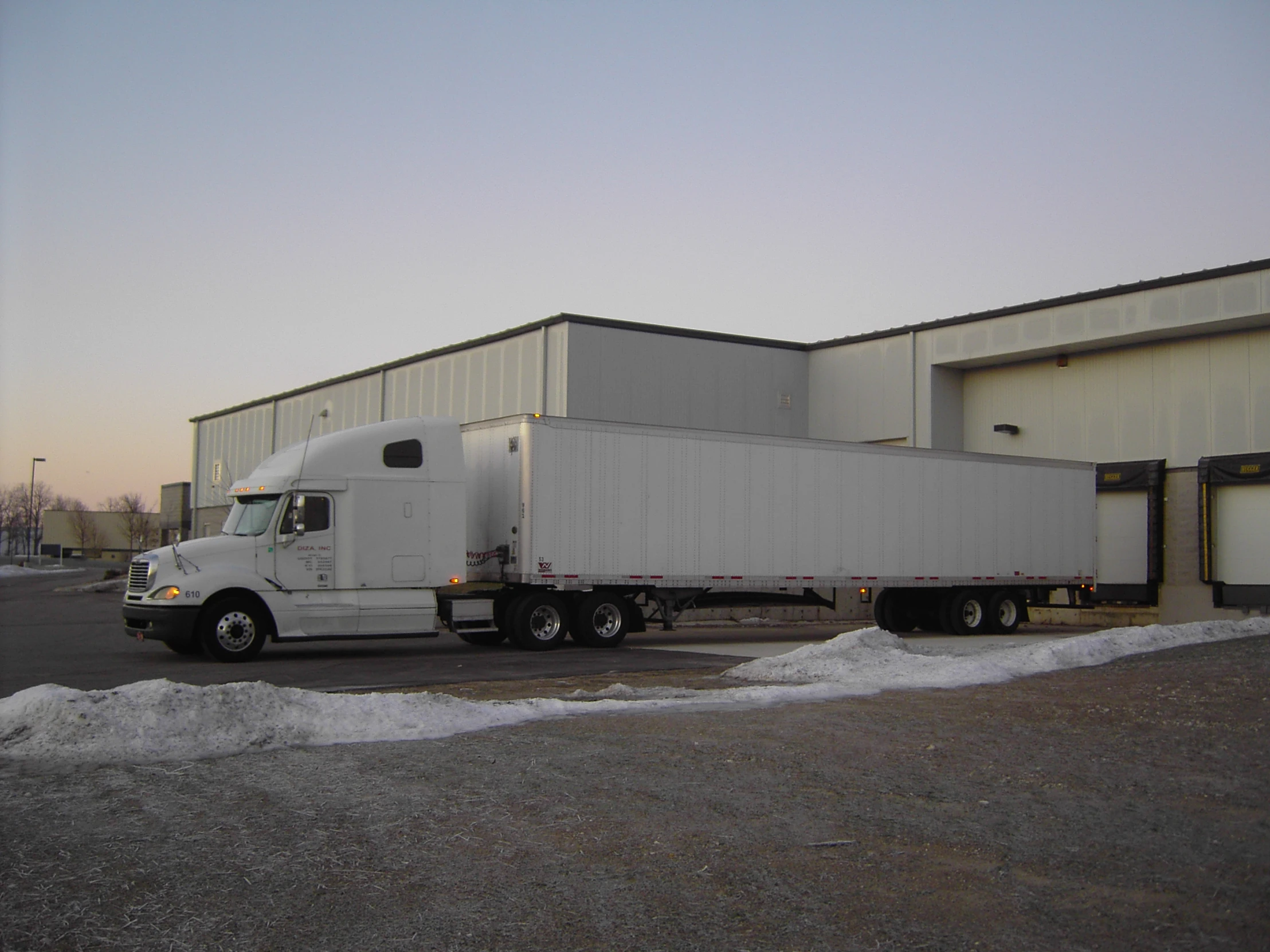 a semi truck parked next to a building