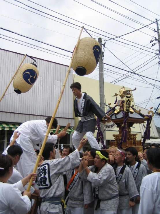 two men in traditional garb are performing a stunt
