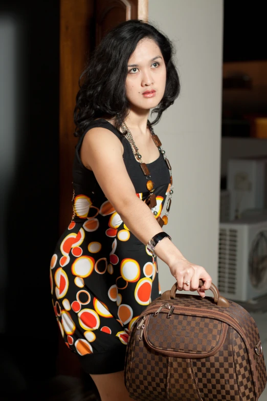 a woman is holding a brown suitcase