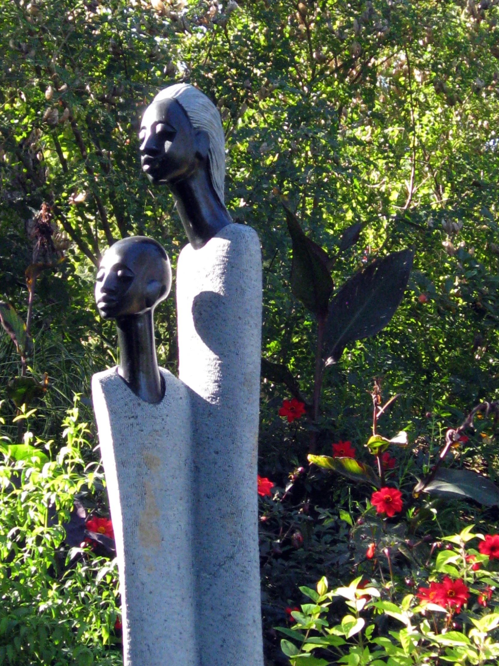 a statue of two women are in the grass