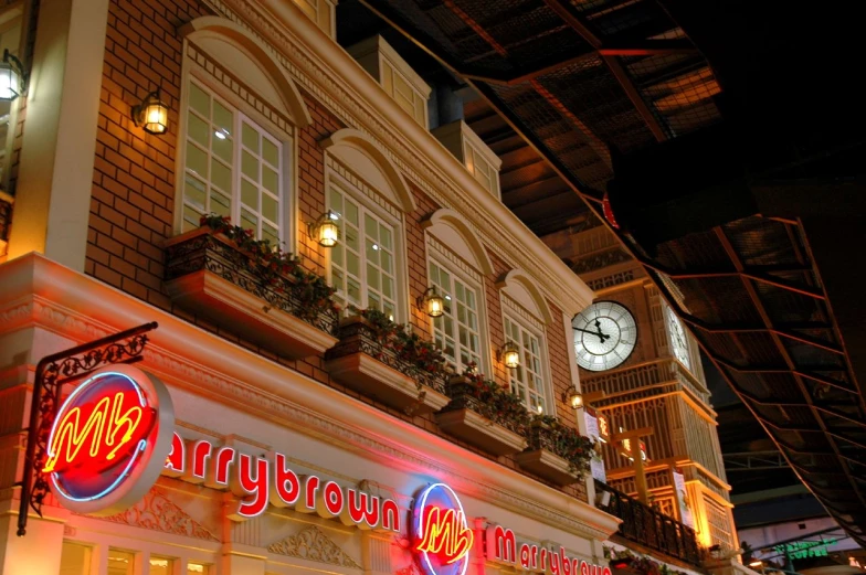 many stores along the side of the street are lit up with various colorful signs