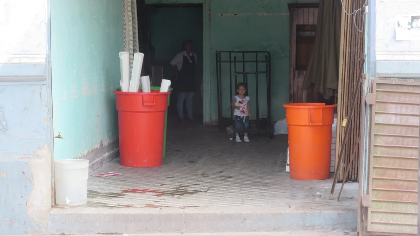 a  standing next to a large orange barrel